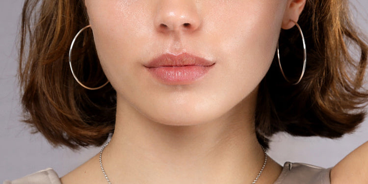 Große silberne Creolen und feine Halskette kombiniert getragen